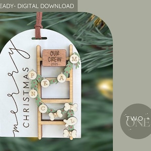 Peut inclure: Ornement de Noël en bois avec un motif d'échelle. L'ornement porte les mots "Merry Christmas" et "Our Crew 2025". L'échelle comporte des lettres et des formes d'os de chien. Un cordon en cuir marron est attaché pour l'accrocher.