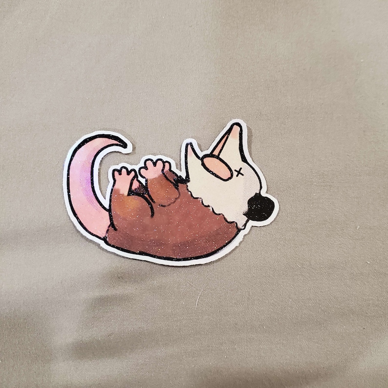 May include: A brown and white cartoon opossum with a pink tail, lying on its back with its mouth open. The opossum is drawn in a simple, cartoon style.
