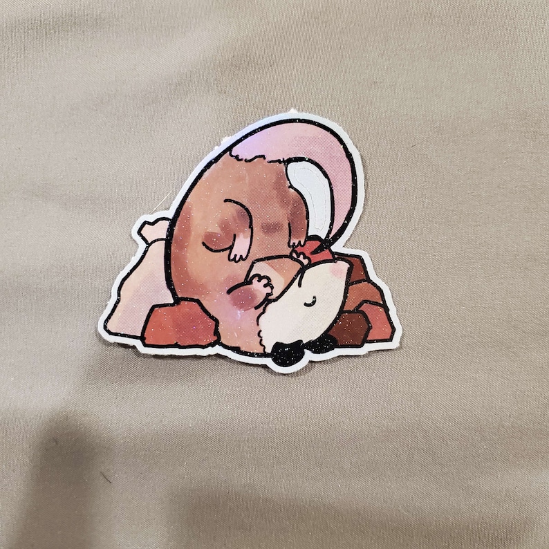 May include: A cartoon illustration of a brown and white opossum curled up on a pile of rocks. The opossum has a pink tail and is sleeping.