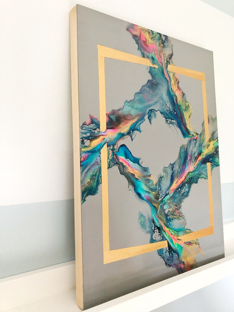 K&ouml;nnte beinhalten: Abstraktes Gem&auml;lde mit goldenem Rahmen auf grauem Hintergrund. Das Gem&auml;lde zeigt wirbelnde Farben in Blau, Gr&uuml;n und Gelb.