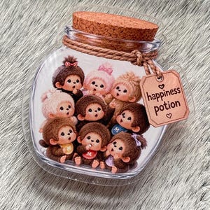 Op de afbeelding: Een doorzichtige glazen pot met een kurken stop, gevuld met negen kleine bruine en roze apenfiguurtjes. Om de hals van de pot zit een bruin touwtje met een beige rechthoekig label met de tekst "happiness potion" en twee kleine hartjes.