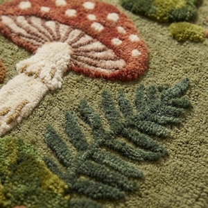 Close up of hand tufted wool rug texture showing raised carved mushroom and fern shapes with thick wool pile loops