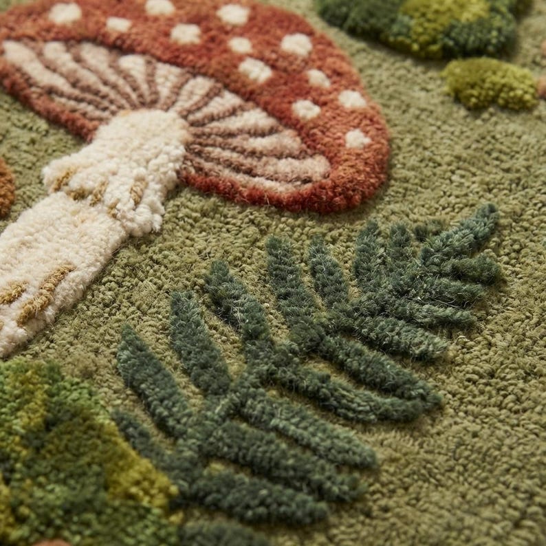 Close up of hand tufted wool rug texture showing raised carved mushroom and fern shapes with thick wool pile loops