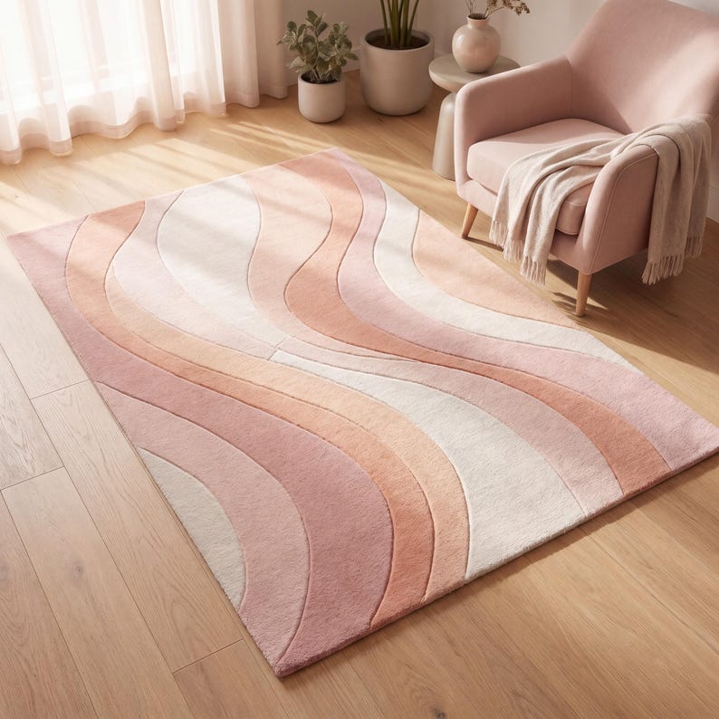 Modern hand tufted wool rug with abstract wave pattern in blush pink peach and ivory tones placed in a bright living room