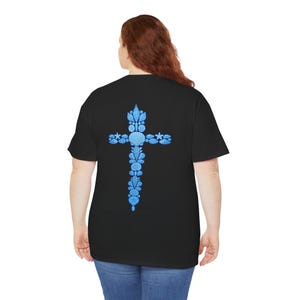 May include: Black t-shirt featuring a blue cross design made of seashells and starfish. The cross is centered on the back of the shirt. The shirt is made of a soft material and has a classic crew neck.
