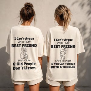 May include: Two off-white t-shirts with black text and illustrations. One shirt says "I Can't Argue With My Best Friend" with an illustration of an older person. The other says "I Can't Argue With My Best Friend" with a toddler illustration.