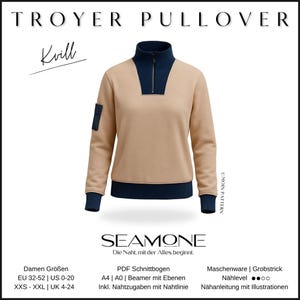 May include: A tan and navy blue Troyer pullover sweatshirt with a high collar and a quarter-zip closure. The sweatshirt has a navy blue pocket on the left sleeve and navy blue cuffs and hem. The text "TROYER PULLOVER" is at the top.
