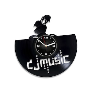 Può includere: Orologio in vinile nero con una silhouette di un DJ che mixa musica. Il quadrante dell'orologio ha numeri e lancette bianchi, e le parole "DJ MUSIC" sono stampate sul disco.