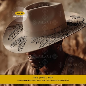 May include: A beige fedora hat featuring a black eagle and feather design on the brim. The hat has a structured crown and a simple band. The text "NO AI HAND-DRAWN" is visible on the hat.