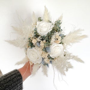 Beautiful bridal bouquet of dried flowers with infinity rose, boutonniere