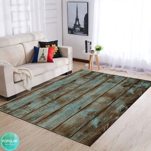 May include: A blue and brown wood-look area rug with a distressed finish. The rug is laid out on a hardwood floor in a living room setting.