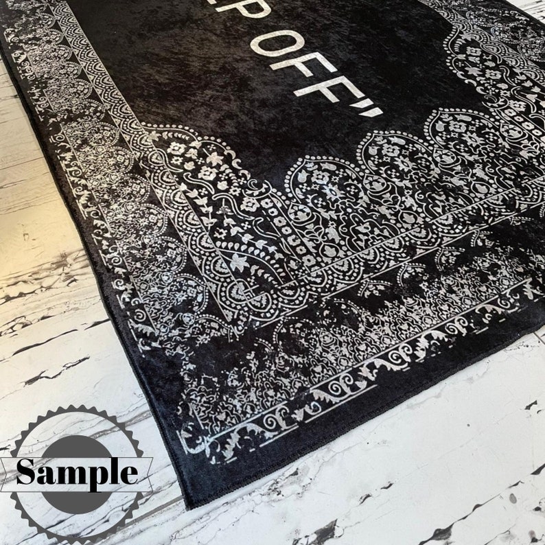May include: Black and white rug with a decorative border and the text "Off" in the center.