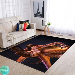 May include: A dark blue rug featuring a large, detailed image of an orange octopus with pink suckers. The octopus is positioned diagonally across the rug, with its tentacles extending towards the bottom right corner.
