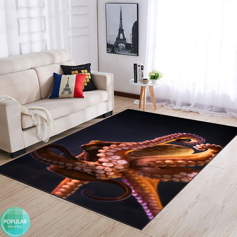May include: A dark blue rug featuring a large, detailed image of an orange octopus with pink suckers. The octopus is positioned diagonally across the rug, with its tentacles extending towards the bottom right corner.