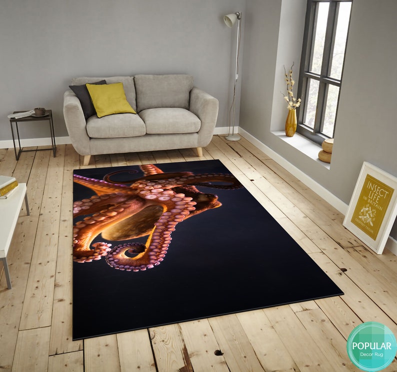 May include: A close-up of a rug featuring a large, orange octopus with pink tentacles against a dark blue background.