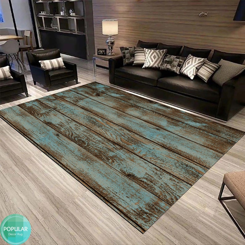 May include: A distressed wood-look rug with a light blue and brown color scheme. The rug is laid out on a hardwood floor in a living room setting.