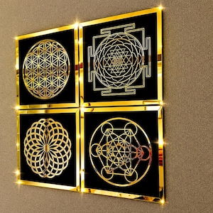 May include: A set of four square wall art panels featuring reflective gold geometric patterns on a black background. Each panel displays a distinct sacred geometry design, including the flower of life, a sri yantra, and other intricate circular motifs.