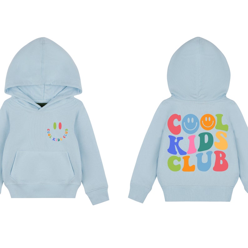 Peut inclure: Un sweat &agrave; capuche bleu clair avec un graphique de visage souriant sur le devant et le texte "Cool Kids Club" en couleurs arc-en-ciel au dos.