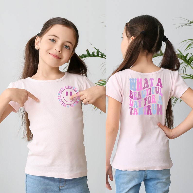 May include: Pink short-sleeved t-shirt with a smiley face graphic on the front and the text "What a beautiful day for a tantrum" on the back.