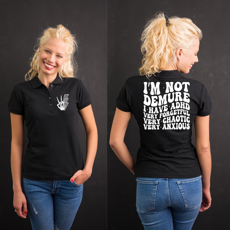 May include: Black polo shirt with white text that reads "I'm not demure I have ADHD very forgetful very chaotic very anxious".
