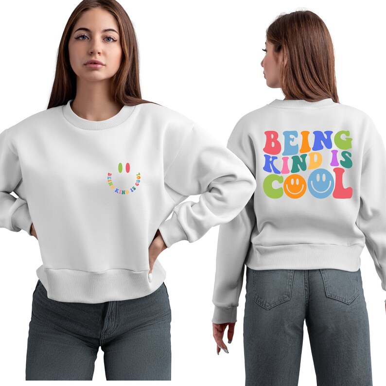 May include: White sweatshirt with a rainbow smiley face on the front and the text "BEING KIND IS COOL" with a rainbow smiley face on the back.