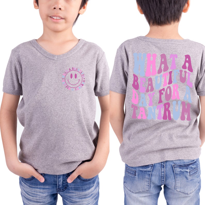 May include: Gray V-neck t-shirt with a smiley face on the front and the text "WHAT A BEAUTIFUL DAY FOR A TANTRUM" in rainbow colors on the back.