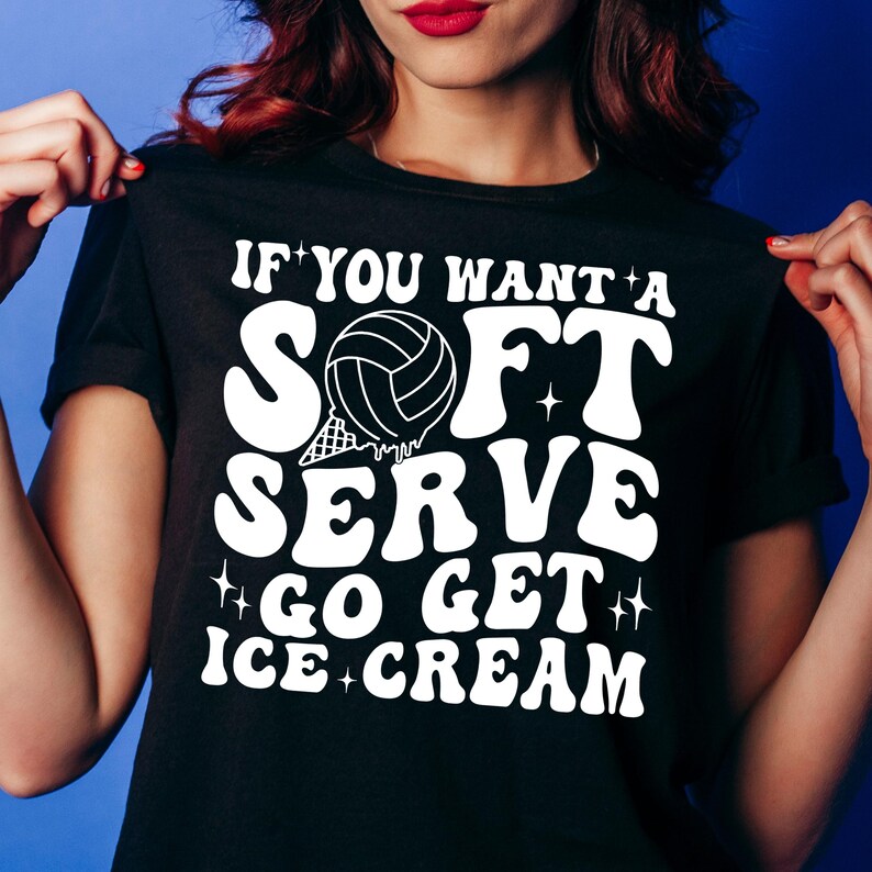 Puede incluir: Camiseta negra con texto blanco que dice "Si quieres un soft serve, ve a por helado". El texto est&aacute; en un estilo de fuente retro. Una pelota de voleibol blanca con una red negra est&aacute; en el medio del texto.
