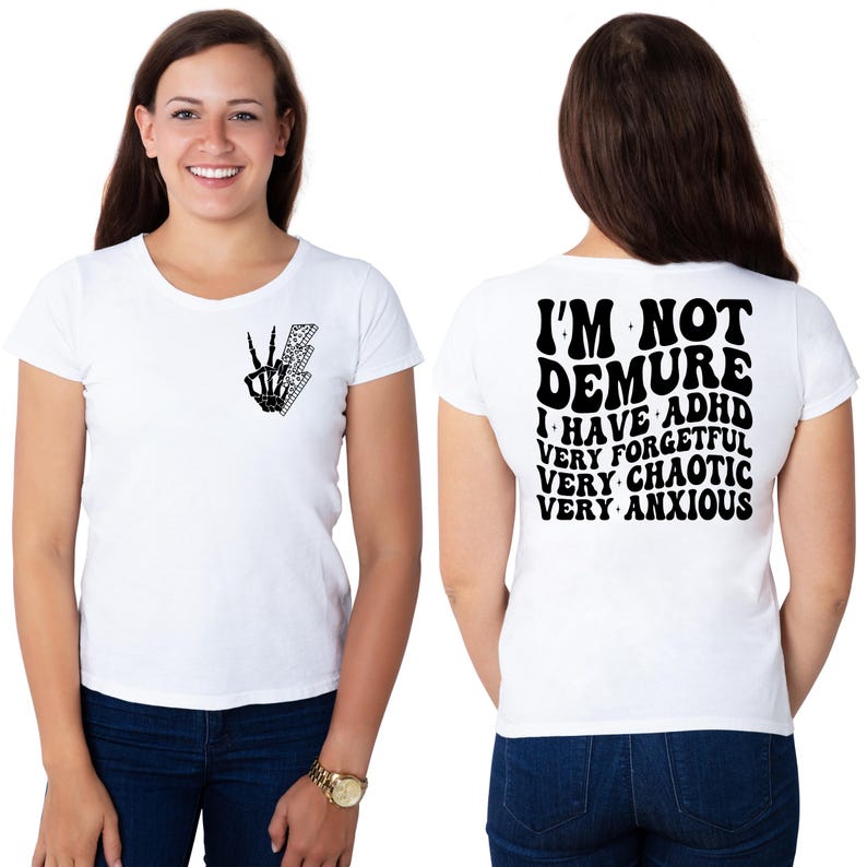 May include: White t-shirt with a black skeleton hand making a peace sign and a lightning bolt on the front. The back of the shirt has black text that reads "I'm not demure I have ADHD very forgetful very chaotic very anxious".