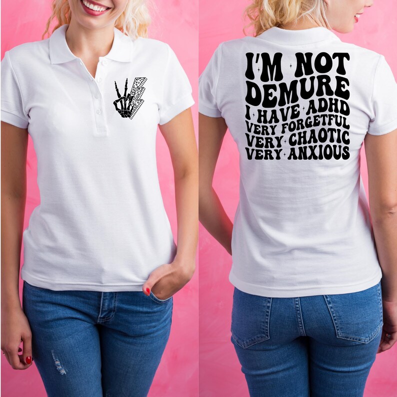 May include: White polo shirt with a black skeleton hand with a peace sign and lightning bolt on the left chest. The back of the shirt has black text that reads "I'm not demure I have ADHD very forgetful very chaotic very anxious".