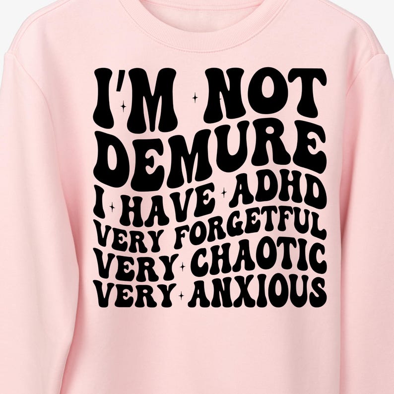 May include: Pink sweatshirt with black text that reads "I'm not demure I have ADHD very forgetful very chaotic very anxious".