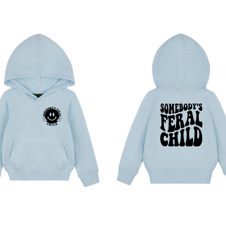Może przedstawiać: Jasno błękitna bluza z kapturem z napisem "Somebody's Feral Child" w kolorze czarnym na plecach i uśmiechniętą buźką z tym samym tekstem w k&oacute;łku z przodu.