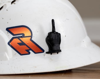 May include: A white hard hat with a black middle finger sticker and an orange and blue logo that says "ER".