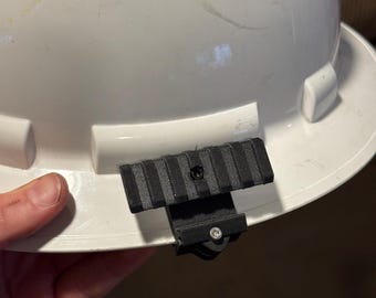 Clip regolabile per visiera del casco con slitta Picatinny.