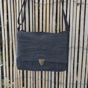 Sac cartable à bandoulière en jean recyclé . Petit sac à main, fermeture bouton poussoir cartable et poche plaquée zippée