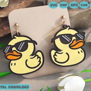 May include: A pair of yellow rubber duck earrings with black sunglasses. The ducks are wearing sunglasses and have a cute expression on their faces.