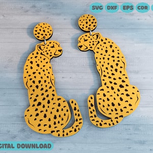 Könnte beinhalten: Ein Paar gelbe Ohrringe in Gepardenform mit schwarzen Flecken. Die Ohrringe sind aus Holz und haben einen kreisförmigen Aufsatz. Das Bild enthält auch den Text "SVG DXF EPS CDR PDF" und "DIGITALER DOWNLOAD".