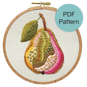 Pode incluir: Design de pêra bordada num bastidor de madeira. A pêra apresenta uma variedade de pontos em tons de verde, amarelo, rosa e castanho. Uma folha verde está presa no topo. O texto "PDF Pattern" está num círculo azul.