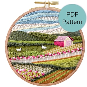 May include: An embroidered landscape scene in a wooden hoop. The scene features a pink barn, green fields, white fences, and two sheep. The sky is blue and white, and the text "PDF Pattern" is on a teal circle.