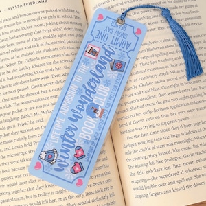 May include: A blue bookmark with a winter wonderland theme. It features a snowy scene with a red and white cabin, a snowman, and a horse-drawn carriage. The bookmark also has the text "Lifetime Admission to the Winter Wonderland Book Club" and "Warming Up With Winter Tales That Melt Our Hearts".