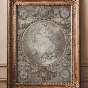 Puede incluir: Una impresión enmarcada de un mapa antiguo con un mapa del mundo circular detallado en el centro. La impresión es en tonos de gris y blanco, con elementos decorativos y un marco de madera detallado. El marco tiene un acabado marrón cálido.
