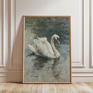 Puede incluir: Pintura vintage enmarcada de un cisne en el agua. El cisne tiene plumas blancas y un cuello curvo, con un pico oscuro. El agua es una mezcla de azules y grises, y el fondo sugiere un estanque o lago.