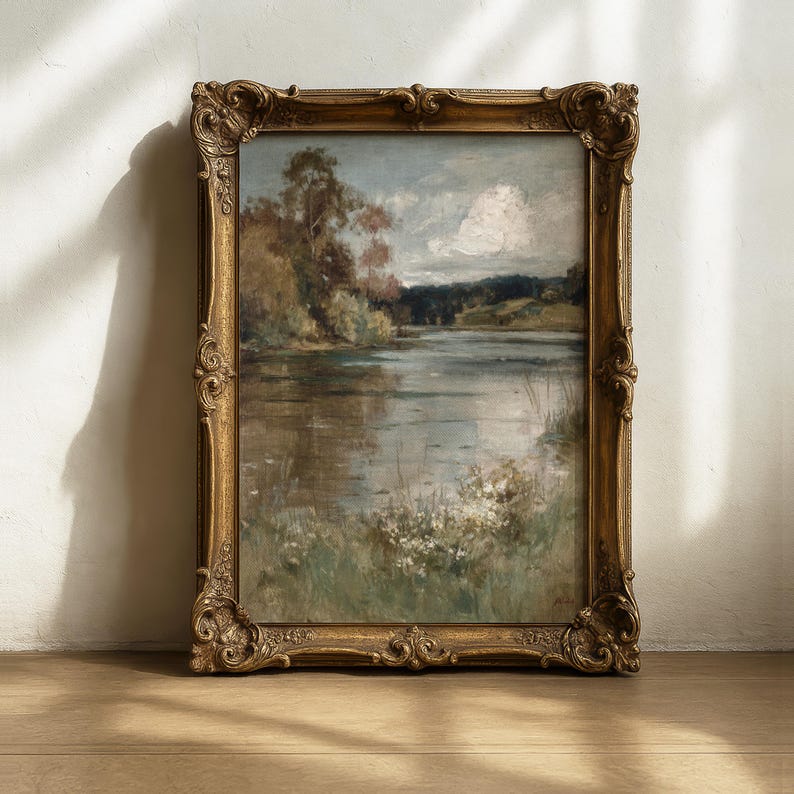 K&ouml;nnte beinhalten: Antike Landschaftsmalerei in einem goldenen, verzierten Rahmen. Das Kunstwerk zeigt eine ruhige Seeszene mit B&auml;umen, grasbewachsenen Ufern und einem bew&ouml;lkten Himmel. Der Rahmen hat detaillierte Schnitzereien.