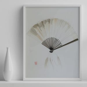 Könnte beinhalten: Ein gerahmter Aquarelldruck eines traditionellen japanischen Fächers. Der Fächer ist in Weiß-, Beige- und Schwarztönen dargestellt, mit einer minimalistischen Ästhetik. Links neben dem gerahmten Kunstwerk befindet sich eine weiße Vase.