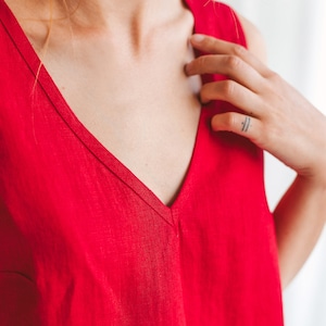 May include: A sleeveless red linen top with a deep V-neckline.