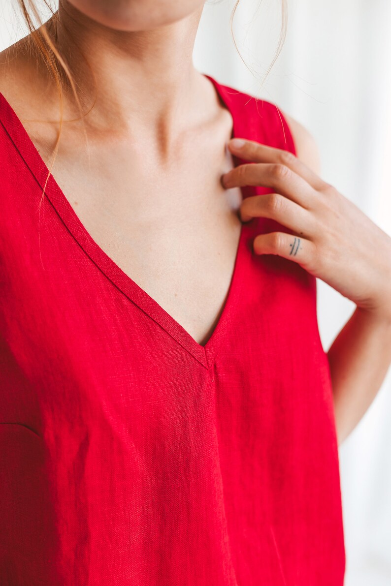 May include: A sleeveless red linen top with a deep V-neckline.