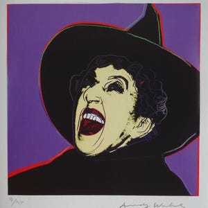 May include: A screen print featuring a stylized portrait of a person wearing a wide-brimmed black witch hat against a purple background. The figure has a pale yellow face, dark hair, and an open mouth with red lips. The print is signed Andy Warhol.