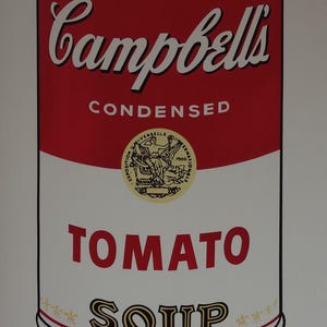 Peut inclure: Une boîte de soupe Campbell's rouge et blanche avec les mots "CONDENSED TOMATO SOUP" imprimés dessus. La boîte a un sceau doré avec une femme tenant une torche. L'image est signée "Andy Warhol" à l'encre noire.
