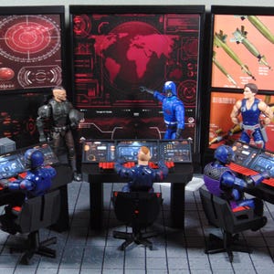May include: A miniature command center playset featuring three black computer consoles with red keyboards and swivel chairs. Five action figures are positioned around the stations, with three seated at computers and two standing before large wall monitors displaying red world maps, radar graphics, and missile imagery.