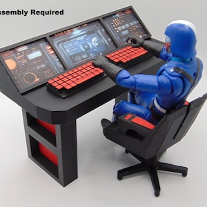 Könnte beinhalten: Ein schwarzer Schreibtisch mit drei Bildschirmen und roten Tastaturen. Eine blaue Actionfigur mit Helm und Uniform sitzt am Schreibtisch und bedient die Bedienelemente. Der Text "Assembly Required" steht oben.