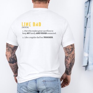 Może przedstawiać: Biała koszulka z nadrukiem "LINE DAD [NOUN] 1. One who makes great sacrifices to keep MY family AND YOURS connected. 2. Like a regular dad but TOUGHER."